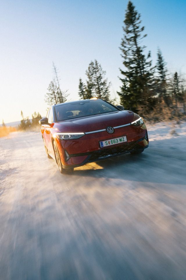 Ein roter ID.7 Tourer GTX fährt eine Landstraße entlang. 