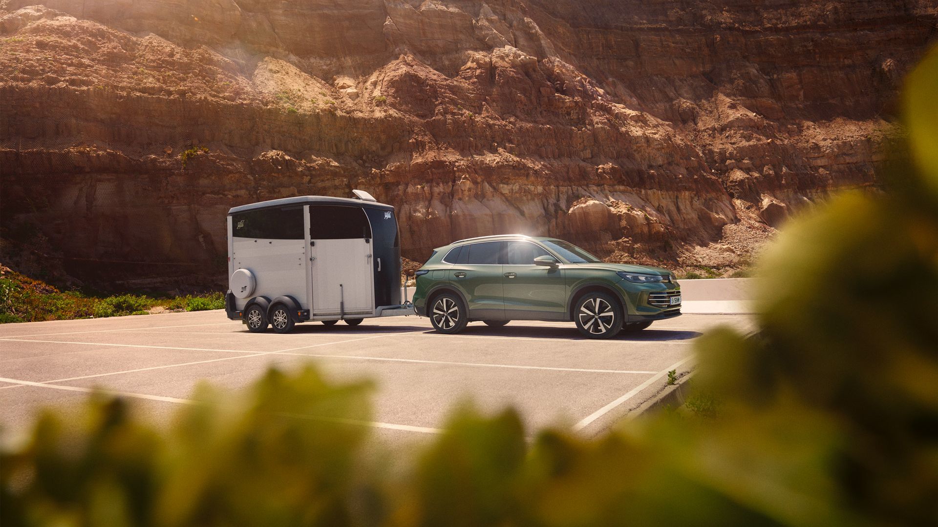 Seitenansicht eines grünen VW Tiguan Elegance mit einem Pferdeanhänger