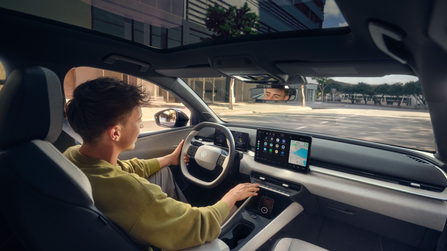 Mann sitzt am Steuer eines VW ID.Polo.