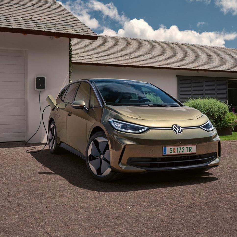 Der VW ID.3 wird an einer Wallbox geladen im Hintergrund ein Einfamilienhaus