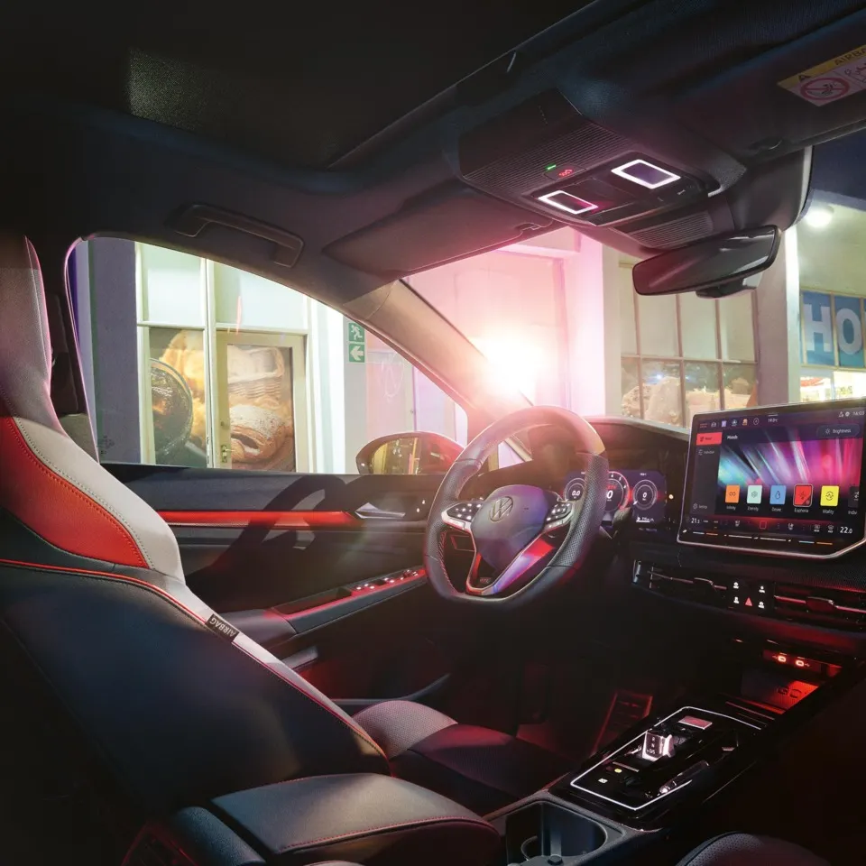 Die Ambientebeleuchtung beleuchtet die Fußräume, Mittelkonsole und weitere Details im Cockpit eines VW Golf GTI.