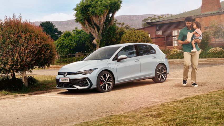 Der VW Golf GTE steht auf einem Parkplatz vor einem Haus.