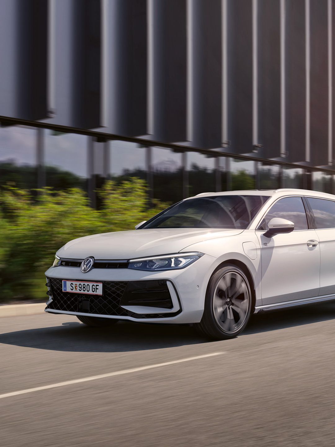 Ein weißer VW Passat R-Line fährt in einer Stadt