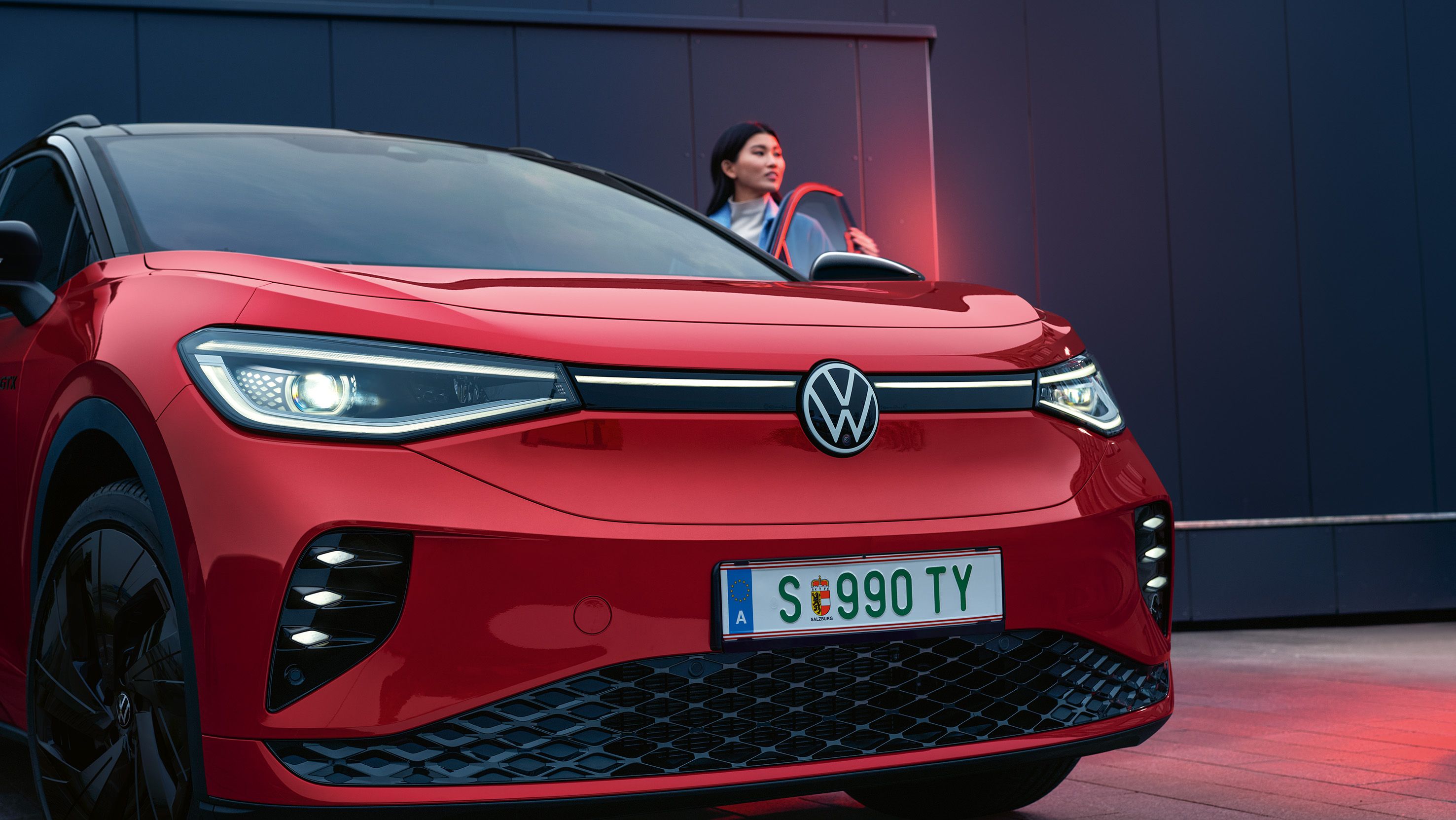 Detailansicht der Frontpartie des VW ID.4 GTX, Frau steigt ein