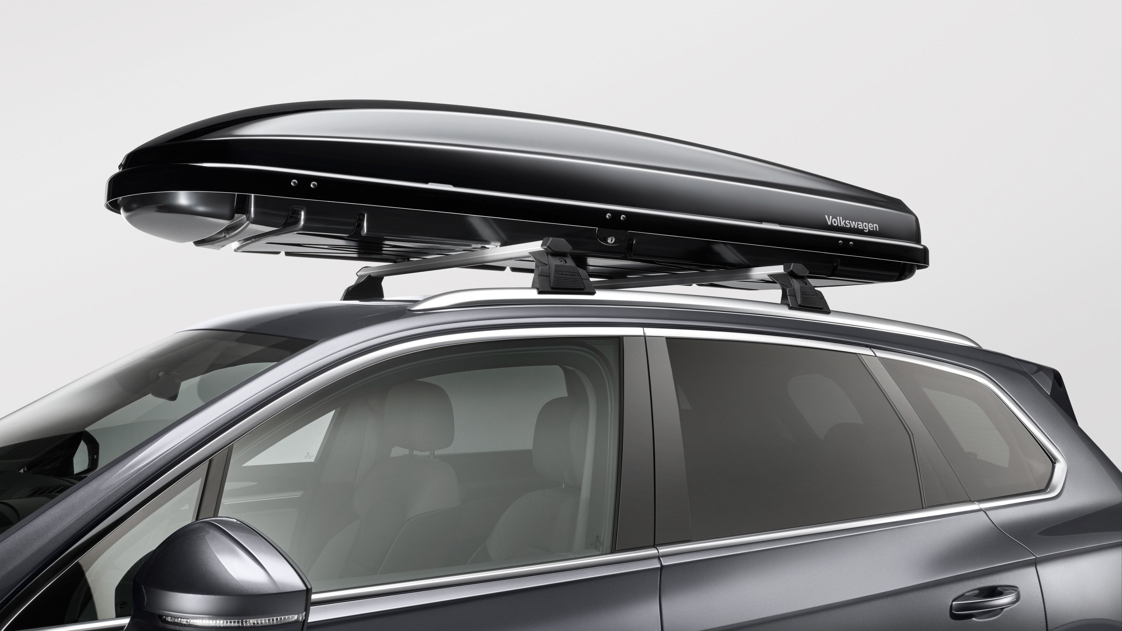 Eine Volkswagen Dachbox auf dem Dach eines schwarzen Volkswagen.