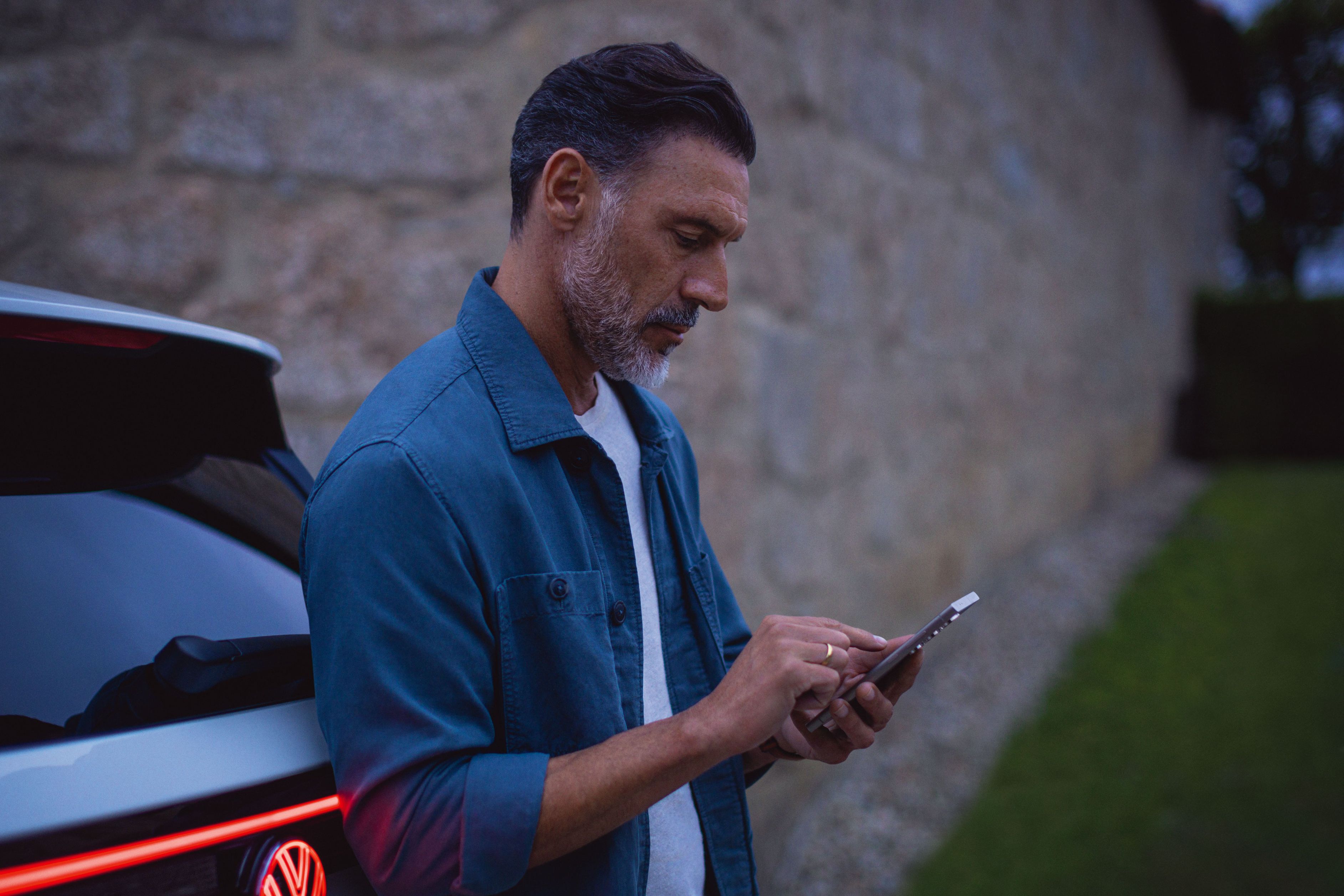 Mann steht am Tayron und schaut auf sein Handy