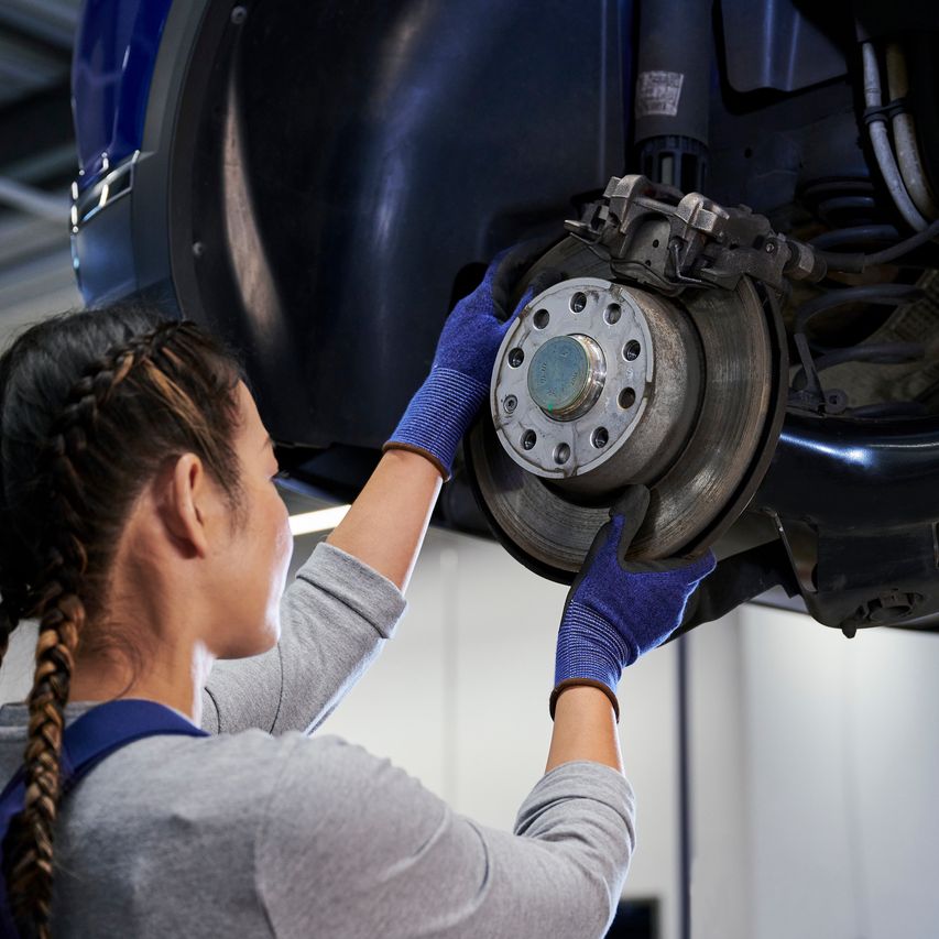 VW Mechanikerin beim Bremsenservice