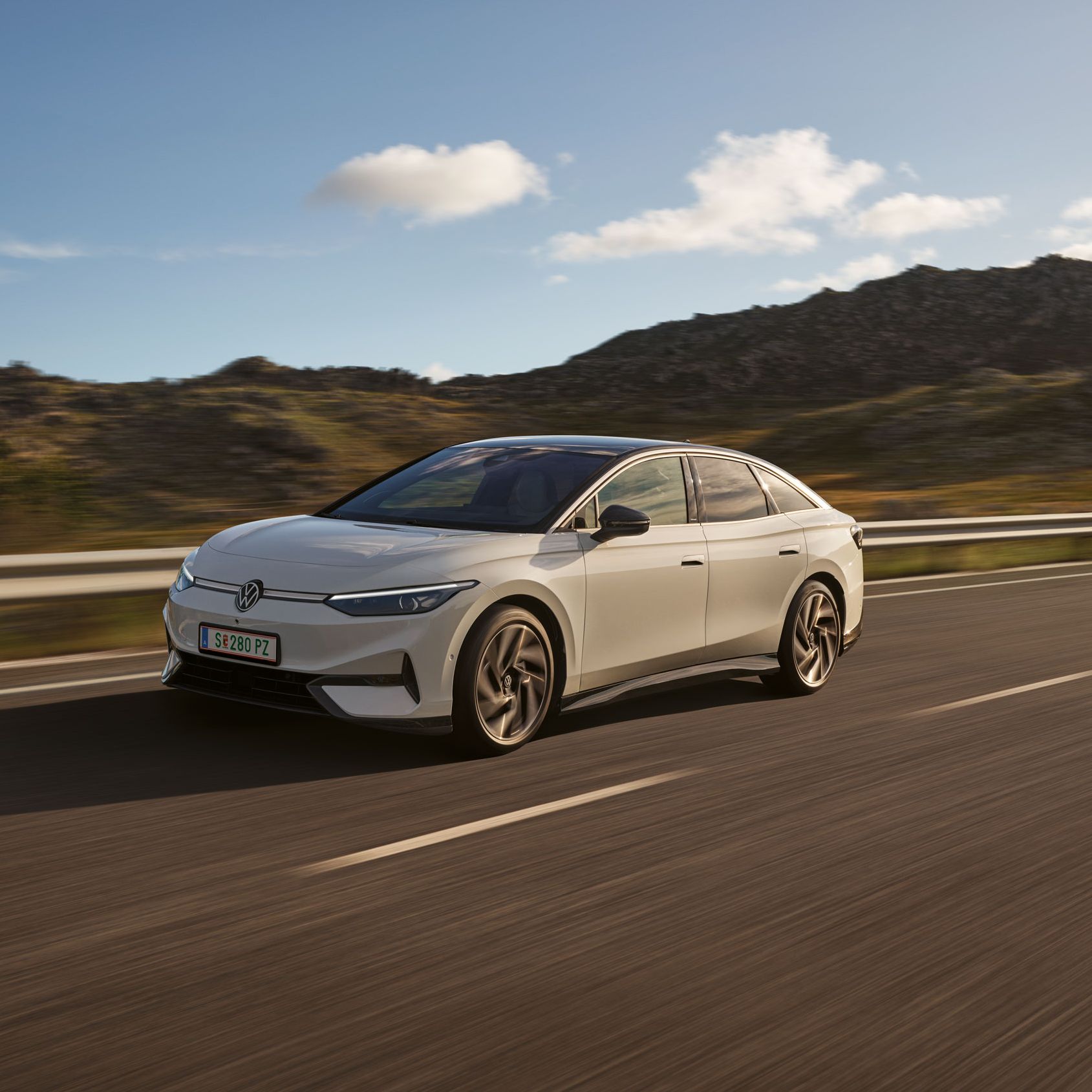 VW ID.7 fährt auf einer Landstraße, Blick auf die aerodynamisch gestaltete Front.