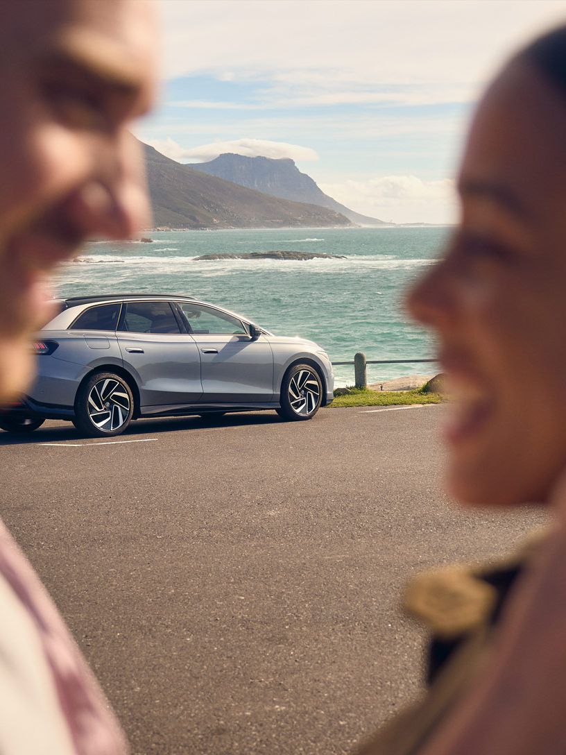 Zwei Personen umarmen sich vor einem ID.7 Tourer.