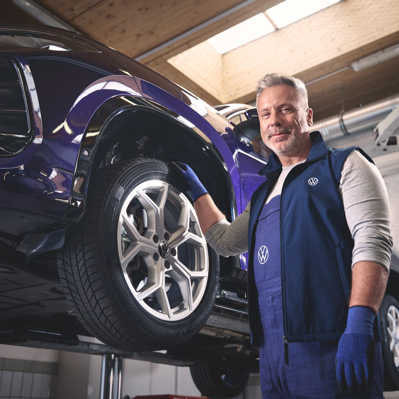 Ein Volkswagen Mechaniker wechselt die Räder bei einem Volkswagen Tayron.
