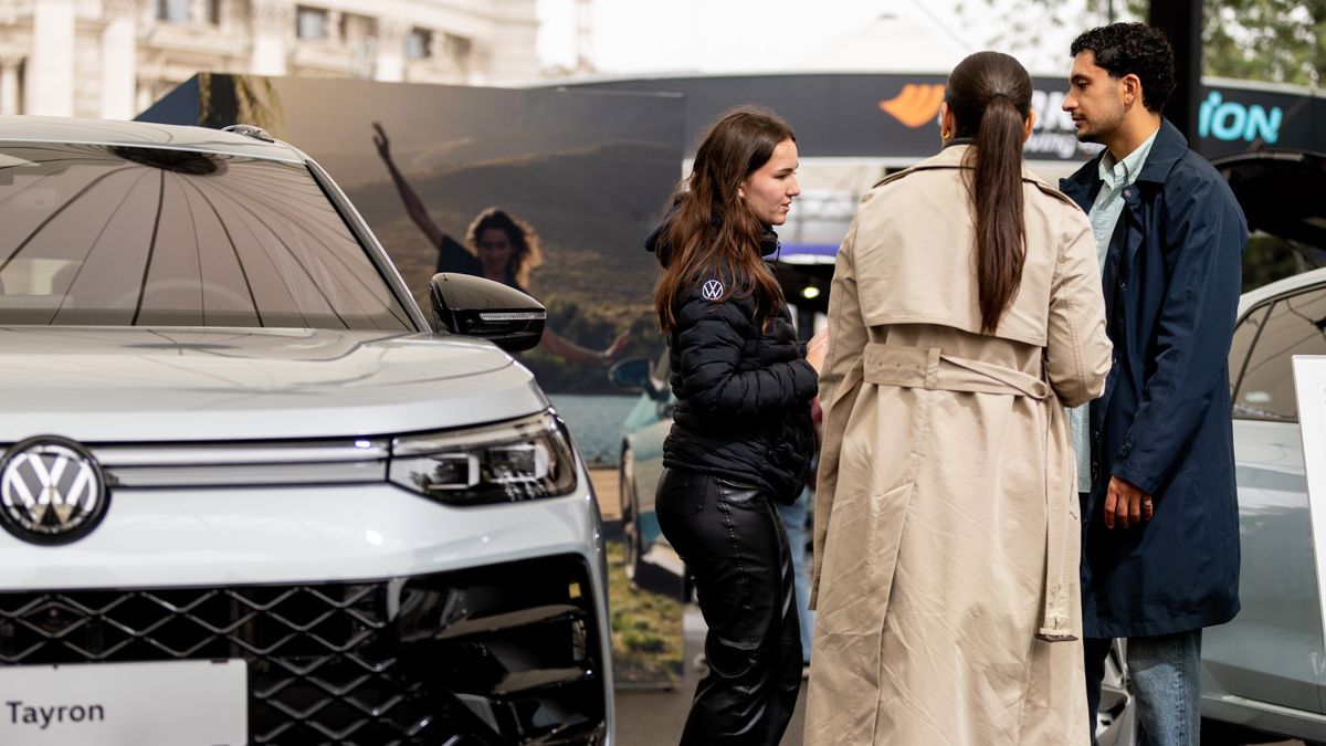 Besucher der Wiener Elektro Tage 2025 erkundigen sich bei einer VW Mitarbeiterin bei der Messe über den Tayron eHybrid.