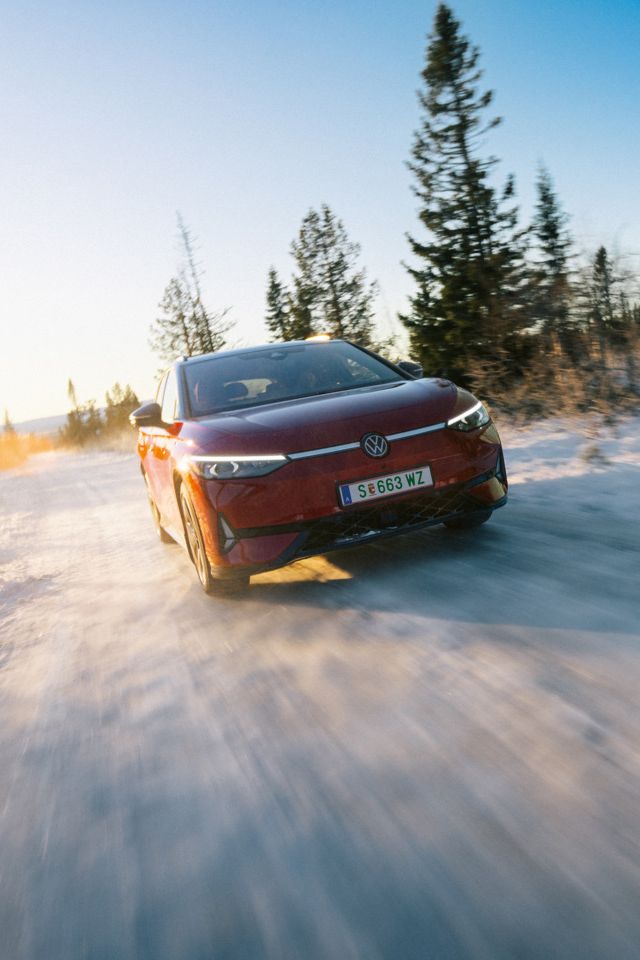 Ein roter ID.7 Tourer GTX fährt eine Landstraße entlang. 