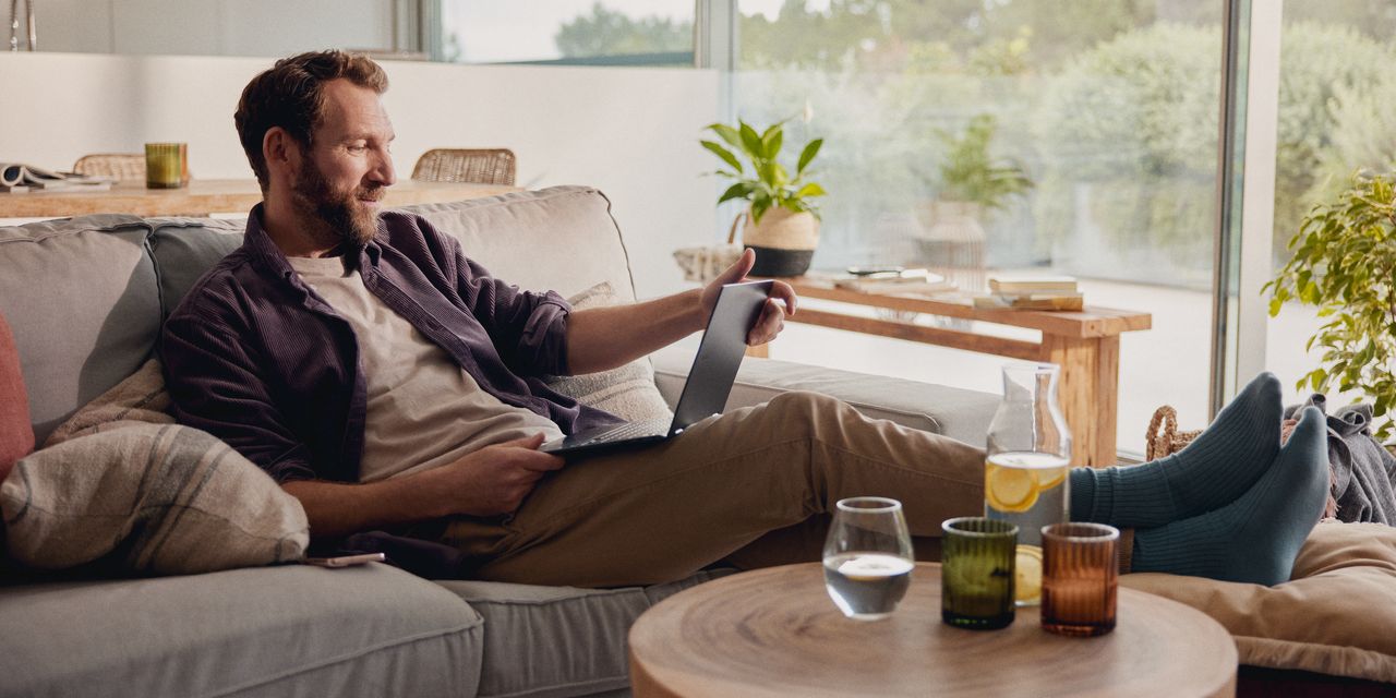 Mann sitzt zu Hause und schaut auf ein Tablet