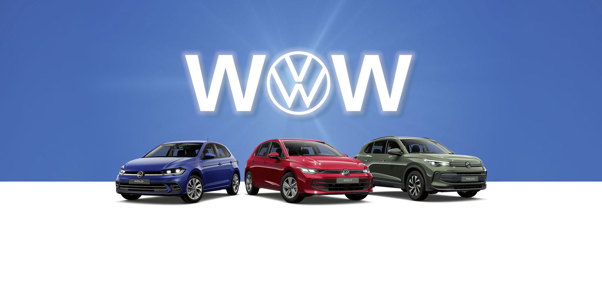 Drei Volkswagen-Autos, ein Polo, Golf und ein Tiguan stehen nebeneinander vor einem blauen Hintergrund. Hinter den Autos ist das Volkswagen-Logo und das Wort "WOW" zu sehen. Die Autos sind von links nach rechts blau, rot und grau.