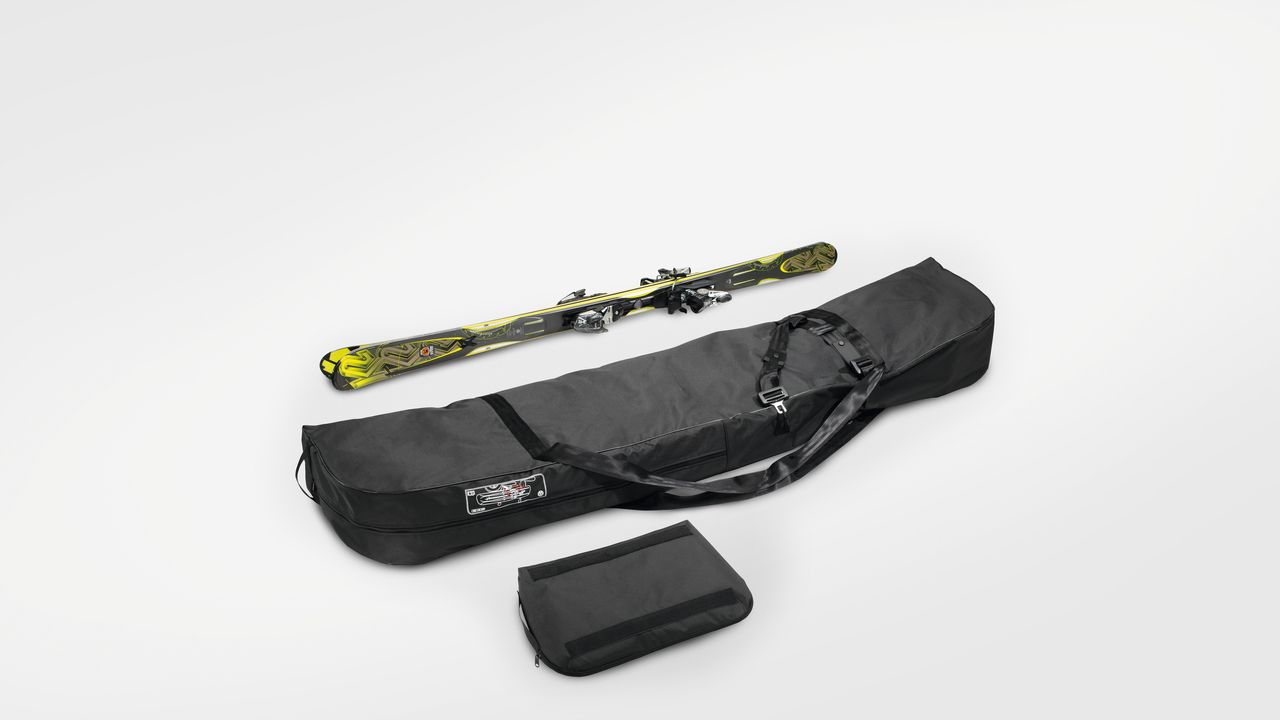 Ein Paar gelbe Ski liegt neben einer Volkswagen Skitasche in schwarz .
