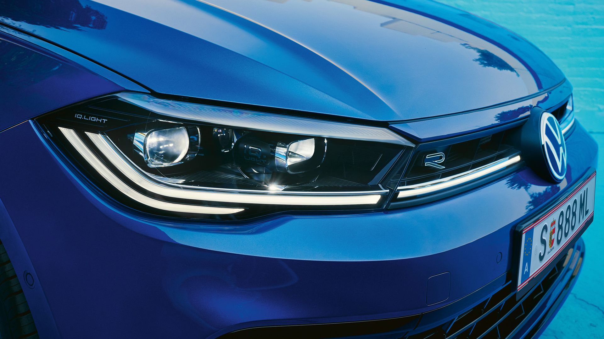 Detailansicht der Front-Lichtsignatur eines blauen VW Polo.