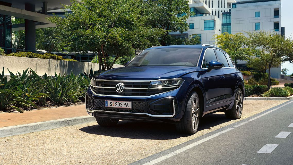Ein Volkswagen Touareg parkt an einer Straße in einer Stadt.