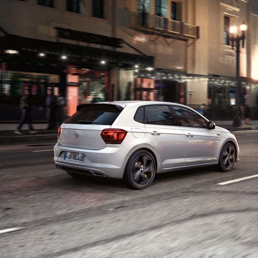 Paar spaziert neben Polo R-Line Vorgängermodell