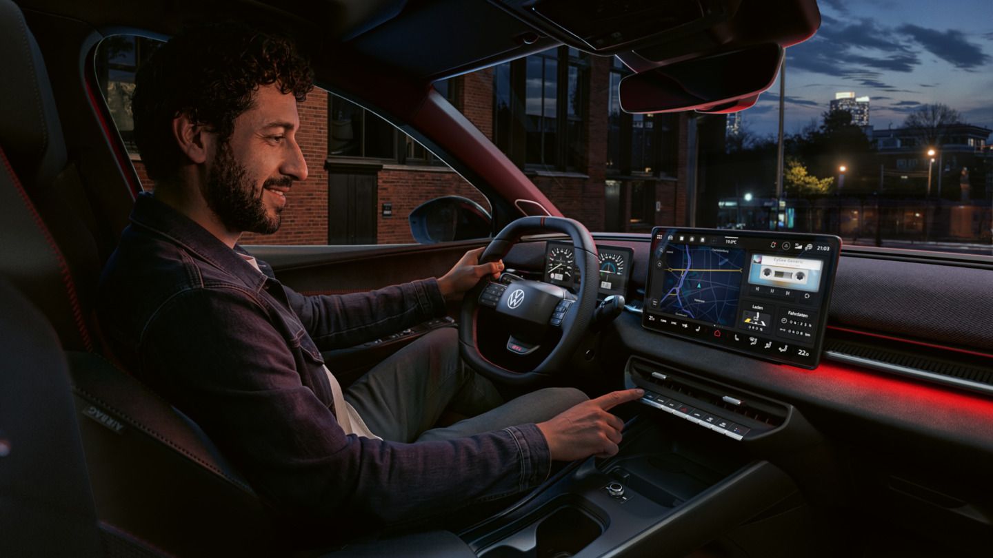 Eine Person bedient einen Knopf des Infotainment-Systems im VW ID. Polo GTI.