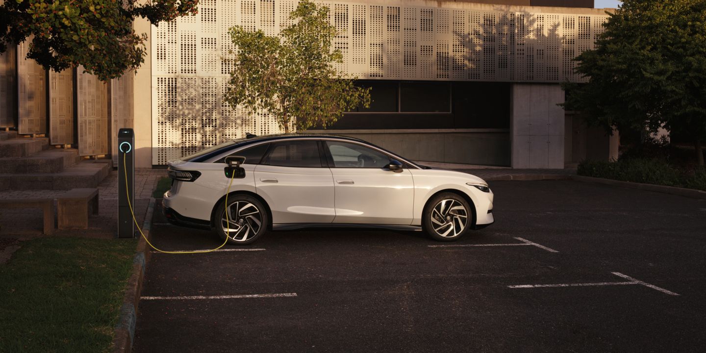 Ein weißer VW ID.7 Pro wird an einer Ladestation geladen.