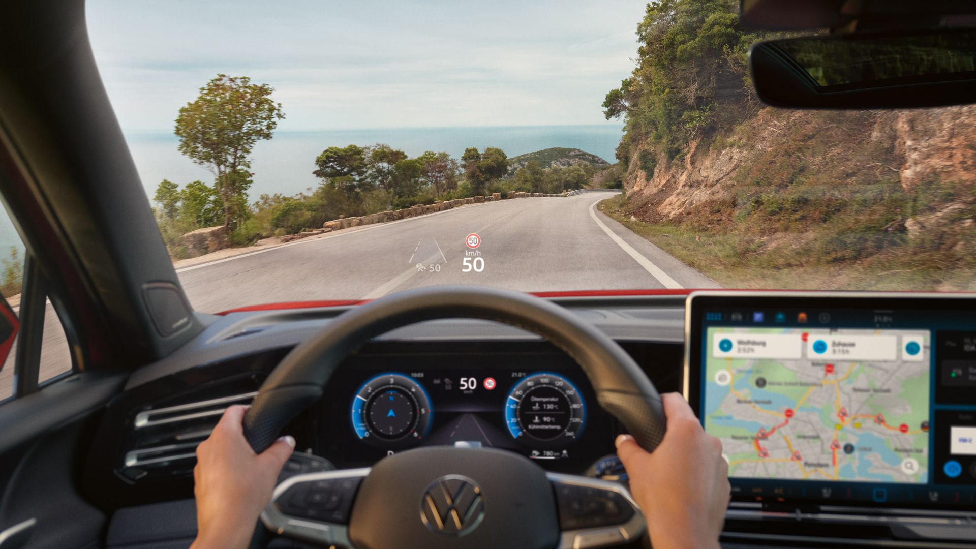 Fahreransicht im VW Tiguan mit Navigationshinweisen des Head-up-Displays auf der Frontscheibe.