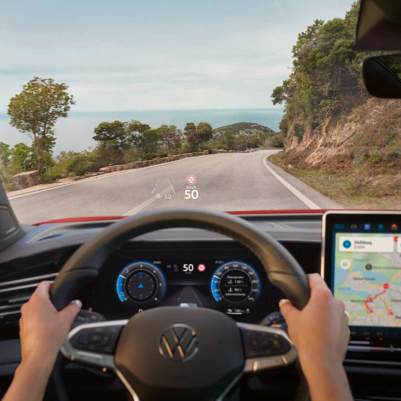 Fahreransicht im VW Tiguan mit Navigationshinweisen des Head-up-Displays auf der Frontscheibe.