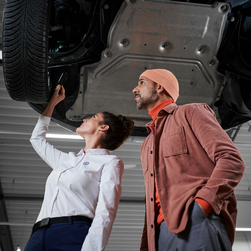 Eine Volkswagen Technikerin bespricht die Reparatur mit einem Kunden