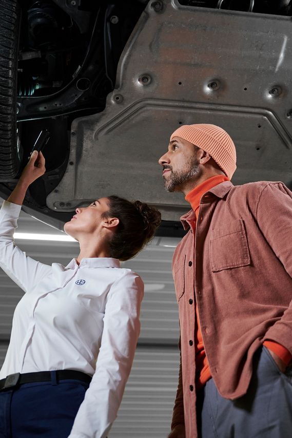 Eine Volkswagen Technikerin bespricht die Reparatur mit einem Kunden
