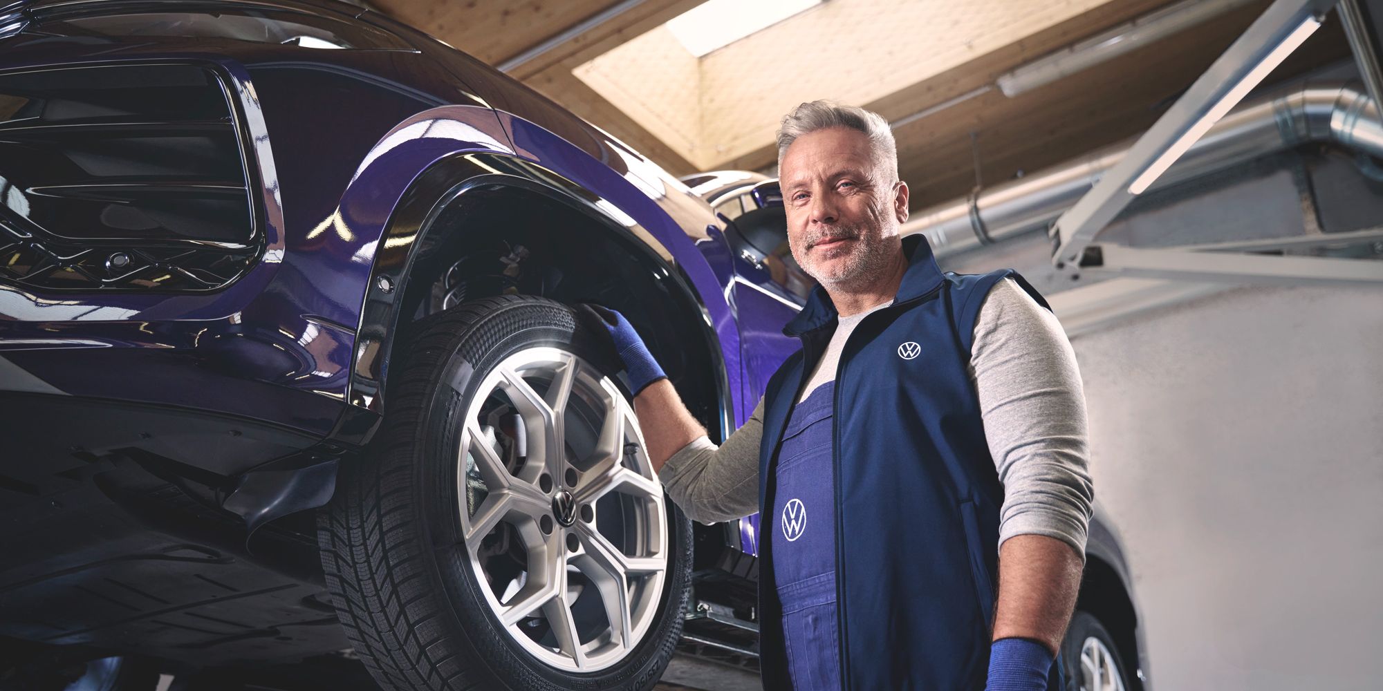 Ein Volkswagen Mechaniker wechselt die Räder bei einem Volkswagen Tayron.