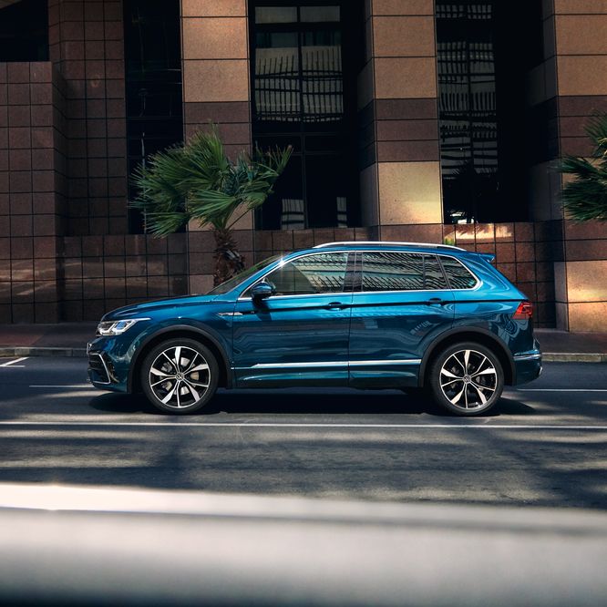 Blauer VW Tiguan fährt auf der Straße durch die Stadt