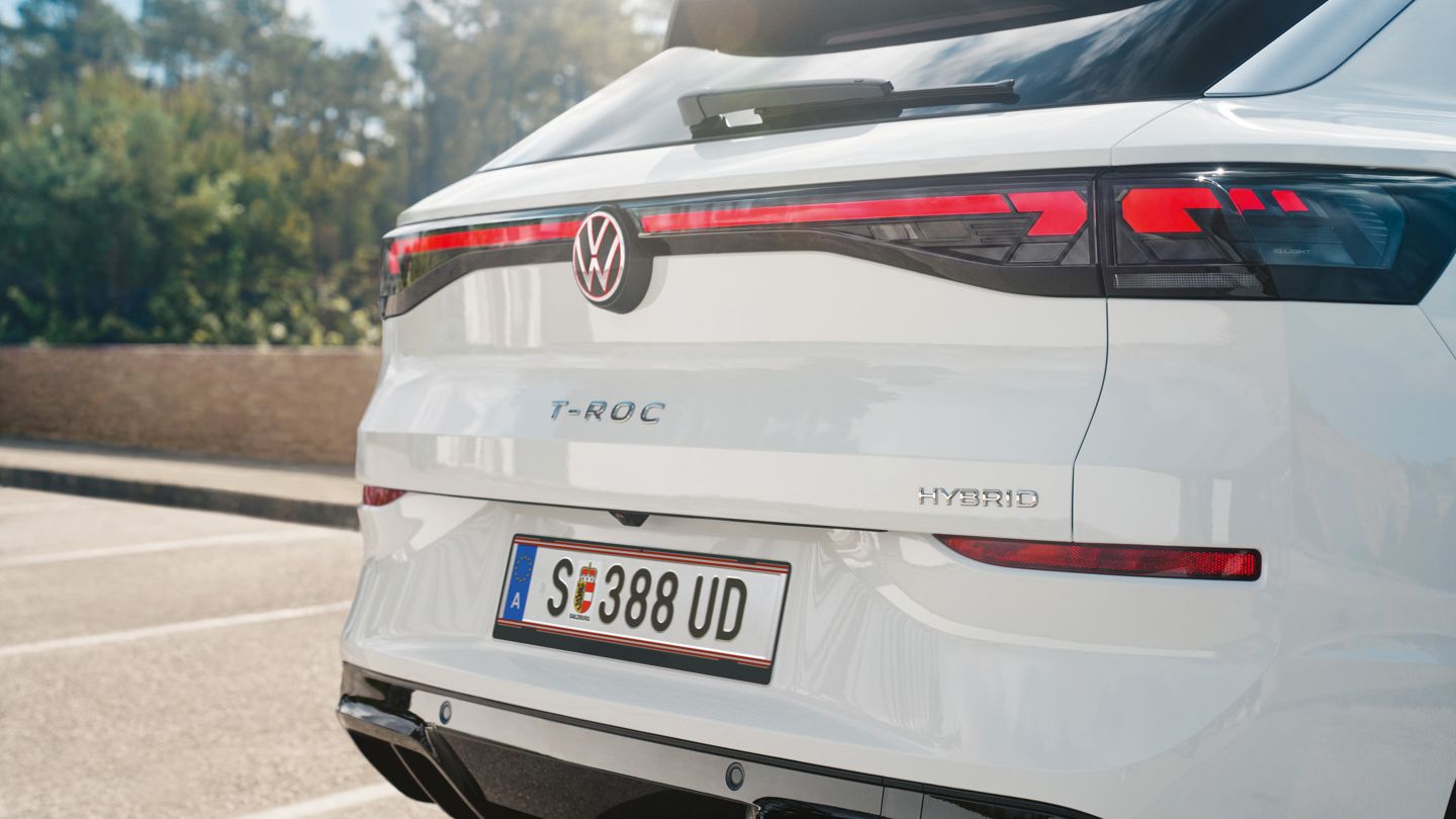 Detailansicht des Hecks eines weißen VW T-Roc Hybrid mit Modellschriftzug.