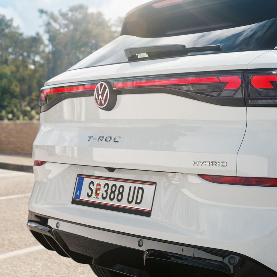 Detailansicht des Hecks eines weißen VW T-Roc Hybrid mit Modellschriftzug.