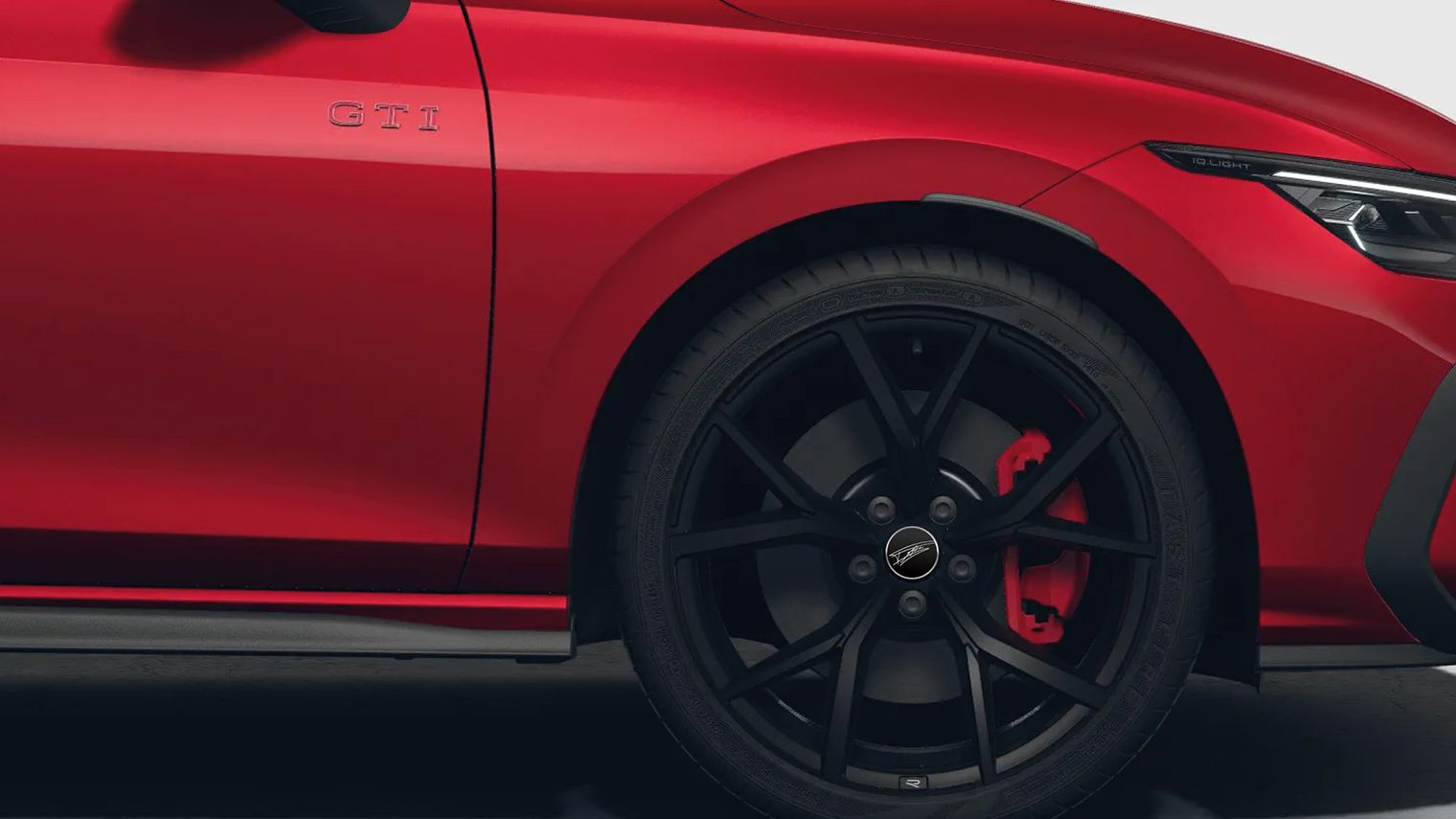 Detailaufnahme eines roten VW Golf GTI Falco Edition in Seitenansicht mit Falco-Felgenkappen und GTI Aufschrift.