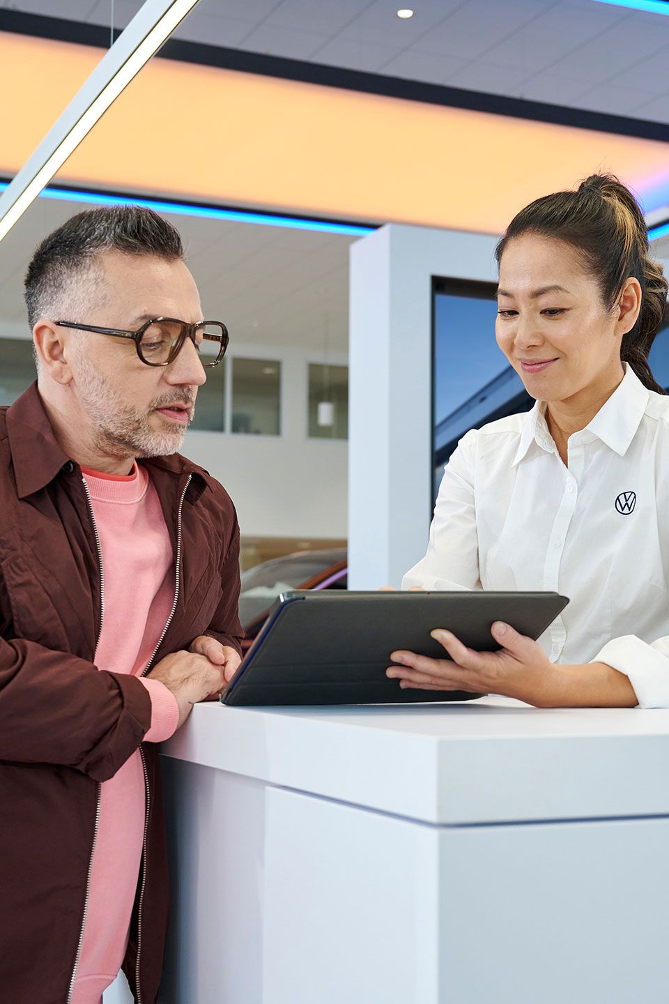 Eine Frau gibt einem Mann mithilfe eines Tablets Informationen.