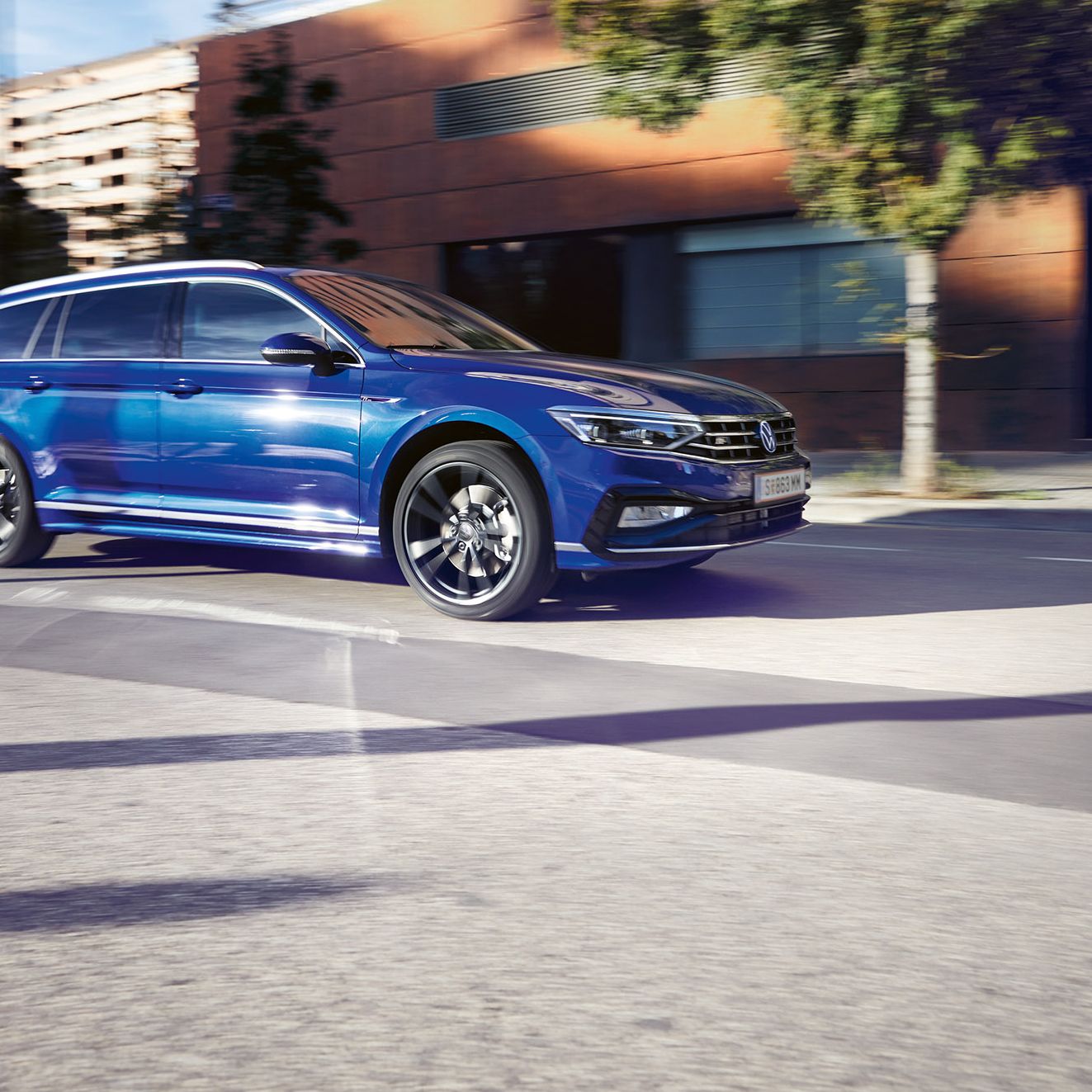 Blauer VW Passat fährt auf einer Straße durch die Stadt