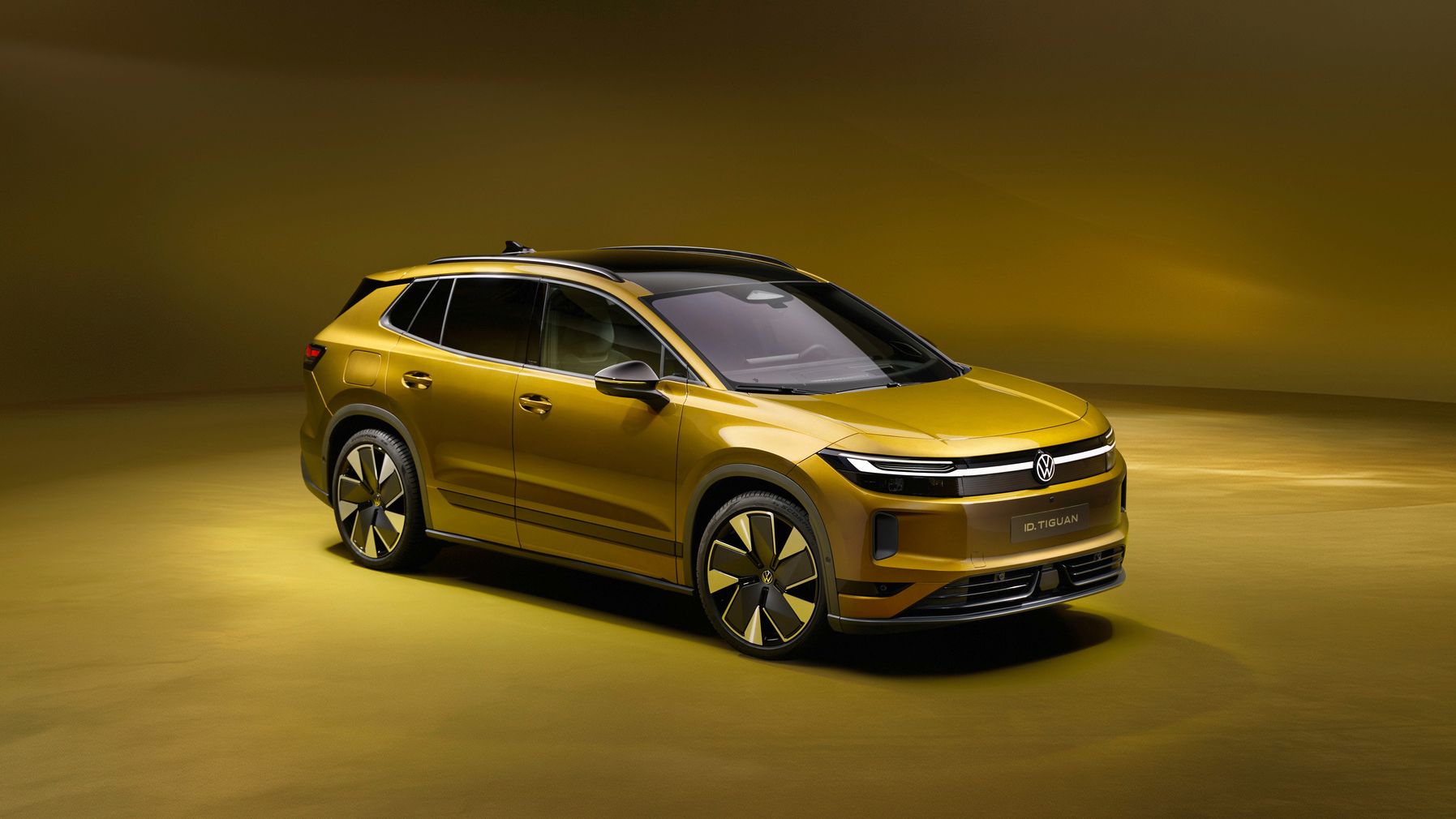 Goldfarbener, moderner SUV in einem Studio mit warm-gelbem Hintergrund. Das Fahrzeug wirkt elektrisch oder hybrid, mit glatten Flächen, schmalen Scheinwerfern und großen, aerodynamischen Felgen. Die Szene ist sauber ausgeleuchtet und betont das Design und die Linienführung des Autos.