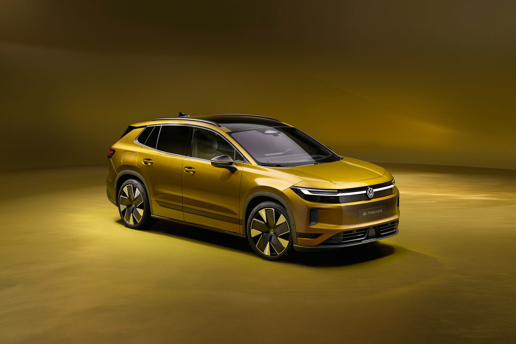 Goldfarbener, moderner SUV in einem Studio mit warm-gelbem Hintergrund. Das Fahrzeug wirkt elektrisch oder hybrid, mit glatten Flächen, schmalen Scheinwerfern und großen, aerodynamischen Felgen. Die Szene ist sauber ausgeleuchtet und betont das Design und die Linienführung des Autos.