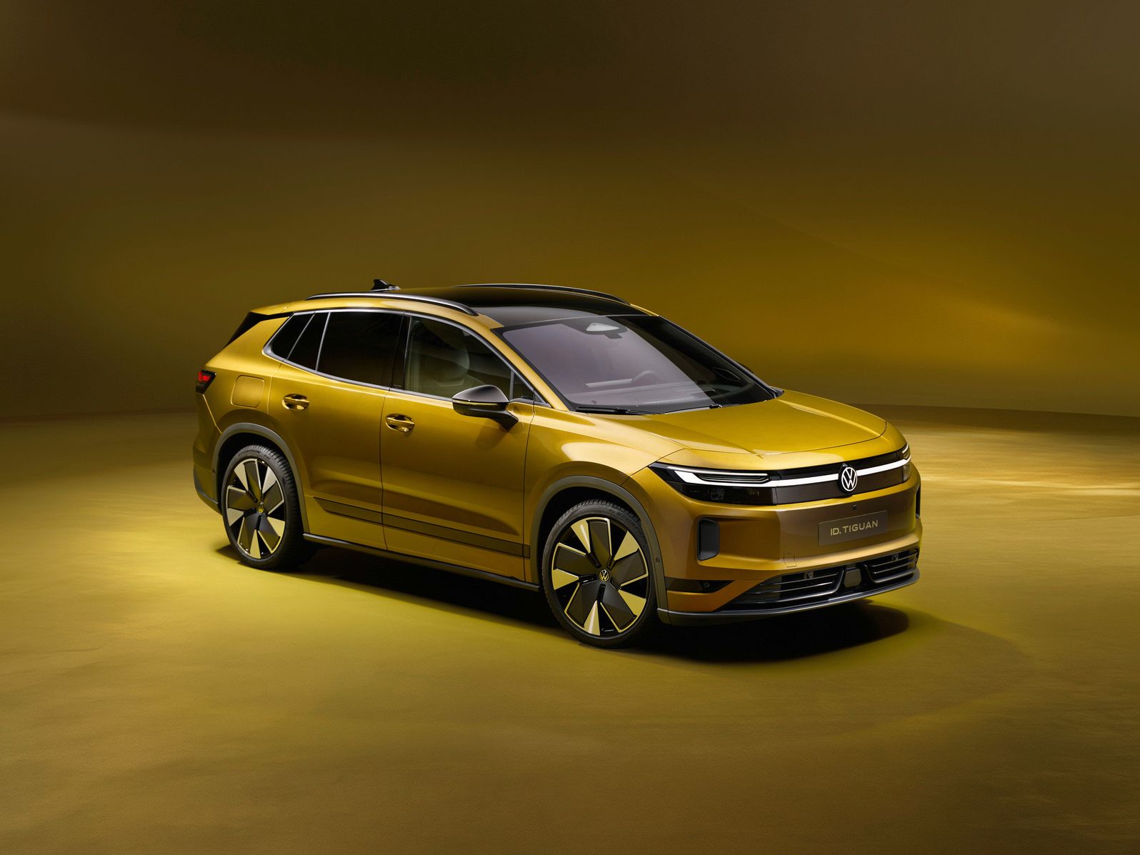 Goldfarbener, moderner SUV in einem Studio mit warm-gelbem Hintergrund. Das Fahrzeug wirkt elektrisch oder hybrid, mit glatten Flächen, schmalen Scheinwerfern und großen, aerodynamischen Felgen. Die Szene ist sauber ausgeleuchtet und betont das Design und die Linienführung des Autos.