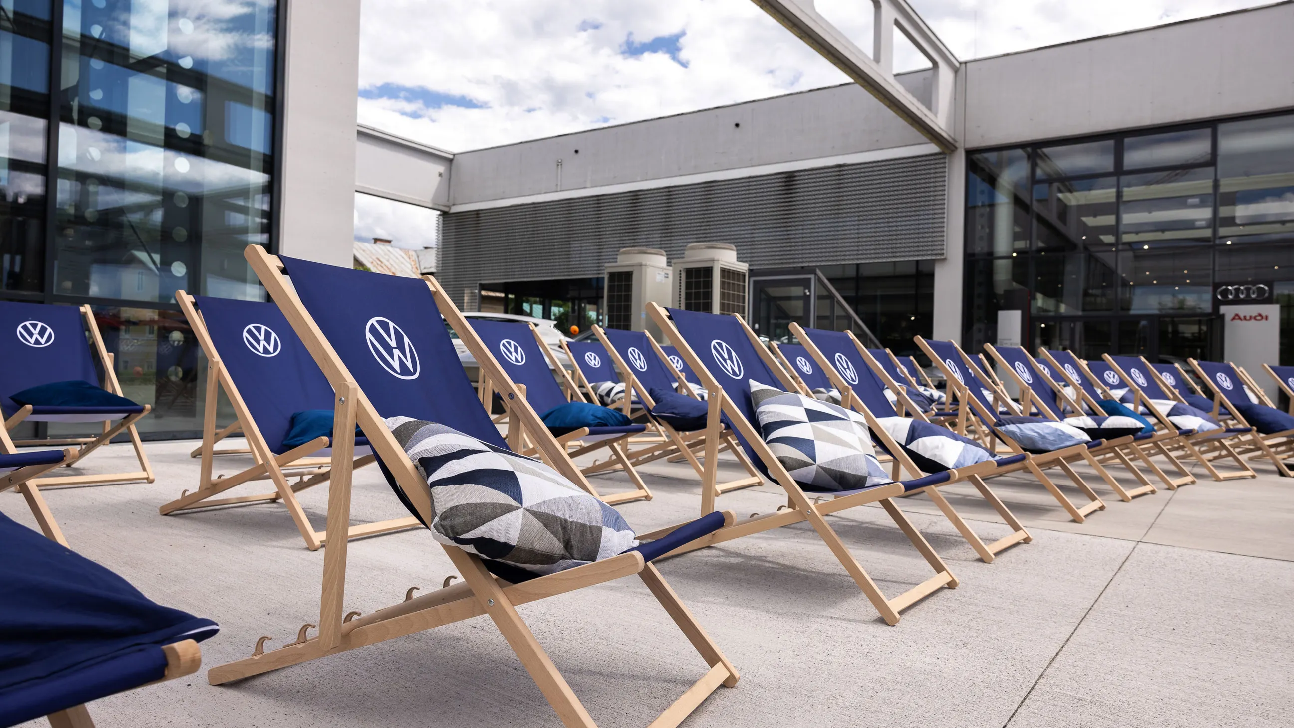 Aufgestellte VW Liegestühle mit Kissen in drei Reihen.