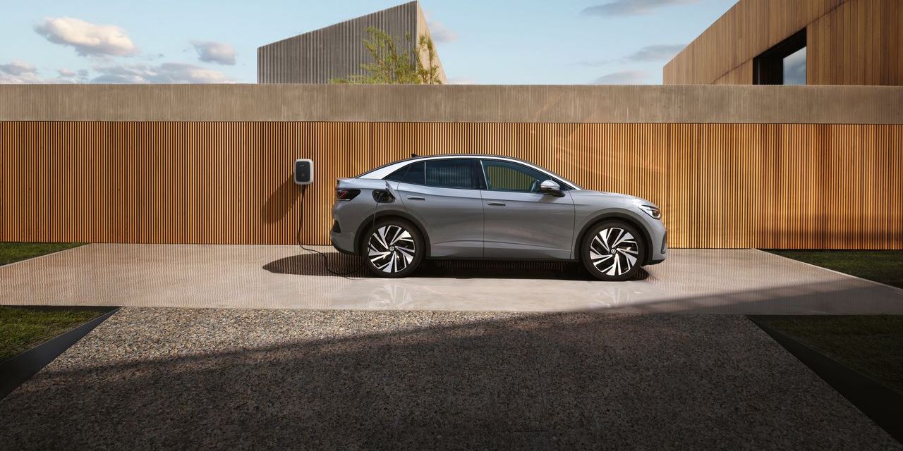 Seitenansicht eines grauen VW ID.5, der an einer Wallbox aufgeladen wird. 