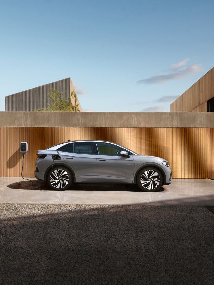 Seitenansicht eines grauen VW ID.5, der an einer Wallbox aufgeladen wird. 