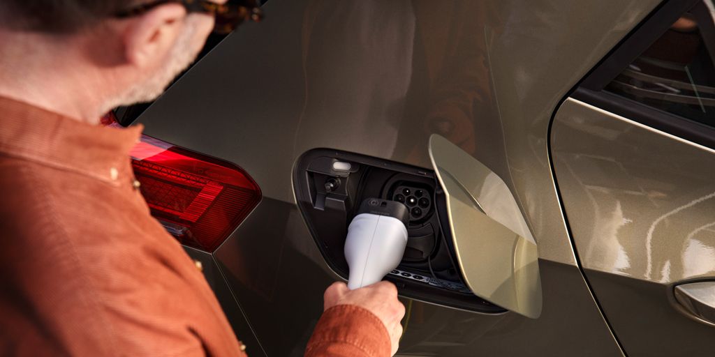 Ein Mann steckt den Ladestecker in die Ladebuchse des VW ID.3