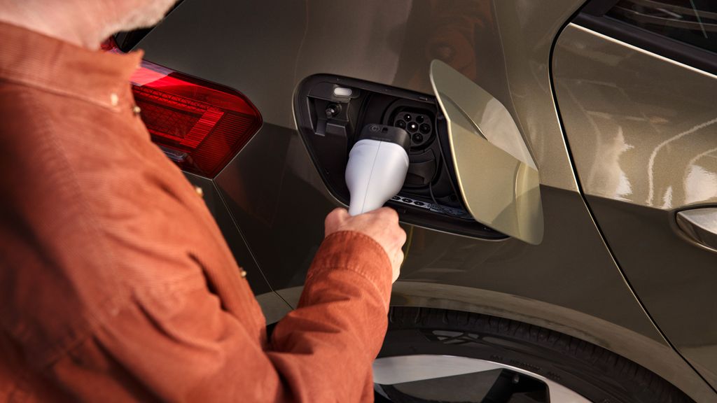 Ein Mann steckt den Ladestecker in die Ladebuchse des VW ID.3