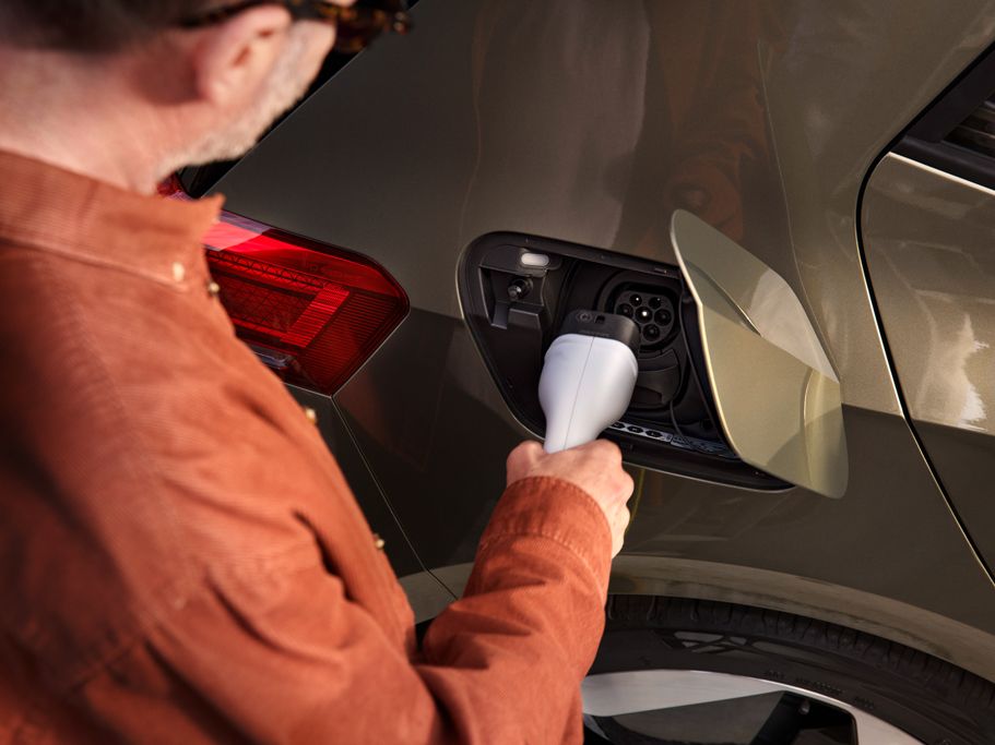 Ein Mann steckt den Ladestecker in die Ladebuchse des VW ID.3