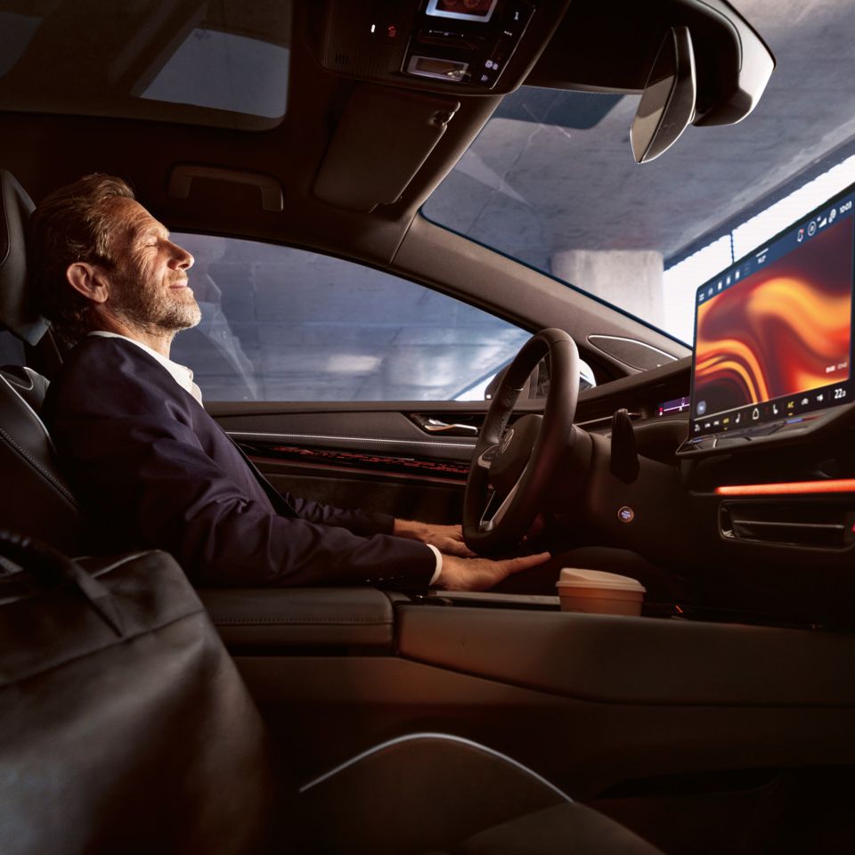 Ein Mann sitzt entspannt im VW ID.7, sichtbar sind Lenkrad und Infotainment-Display.