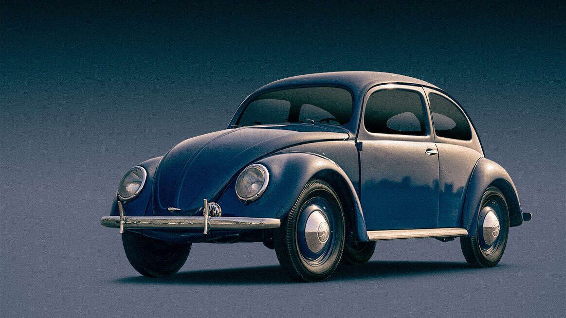 Blauer VW Beetle Oldtimer Blauer, klassischer VW Käfer vor neutralem, dunklem Hintergrund.
Das Auto ist von schräg vorn zu sehen, mit runden Scheinwerfern, glatten Radkappen und verchromten Stoßstangen.