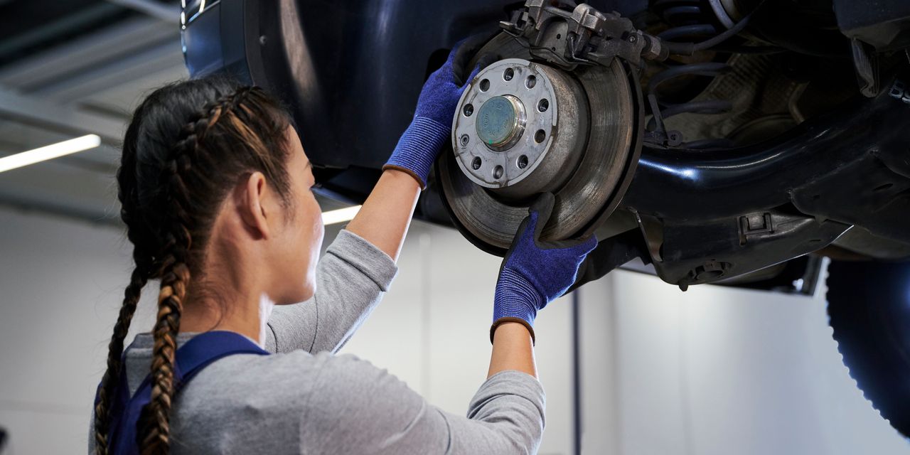 VW Mechanikerin beim Bremsenservice