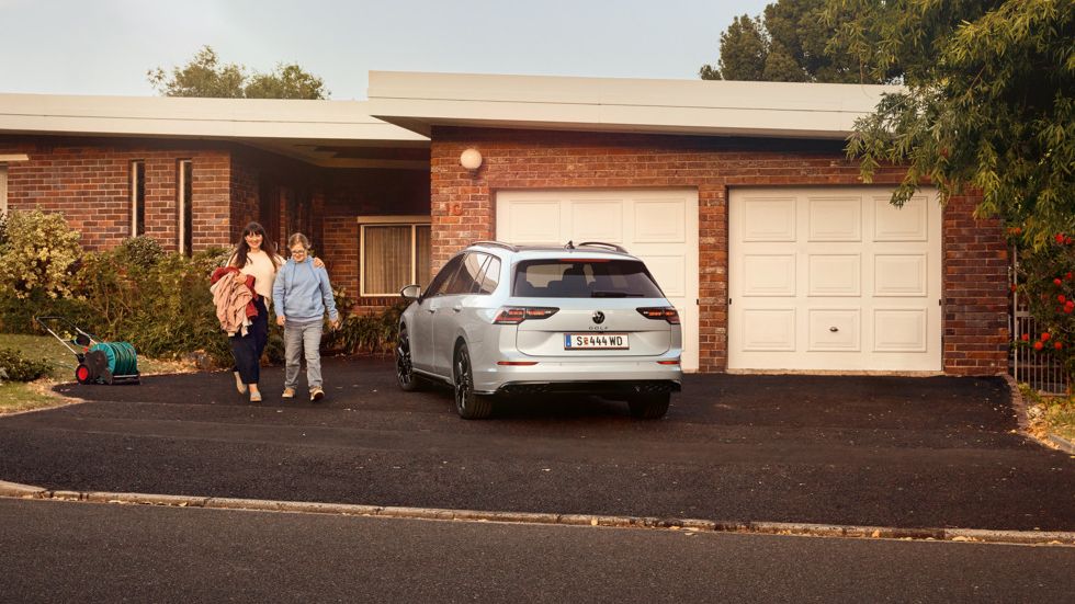 Heckansicht eines VW Golf Variant in der Farbe Ice Blue Metallic geparkt vor Einfamilienhaus
