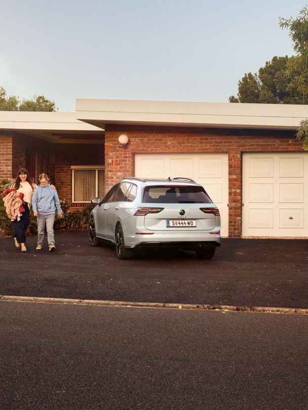 Heckansicht eines VW Golf Variant in der Farbe Ice Blue Metallic geparkt vor Einfamilienhaus