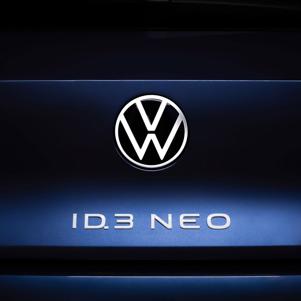Nahaufnahme des Hecks eines Volkswagen ID.3 NEO. Im Zentrum ist das Volkswagen-Logo beleuchtet, darunter steht der Schriftzug "ID.3 NEO". Die Rücklichter sind auf beiden Seiten des Logos sichtbar.